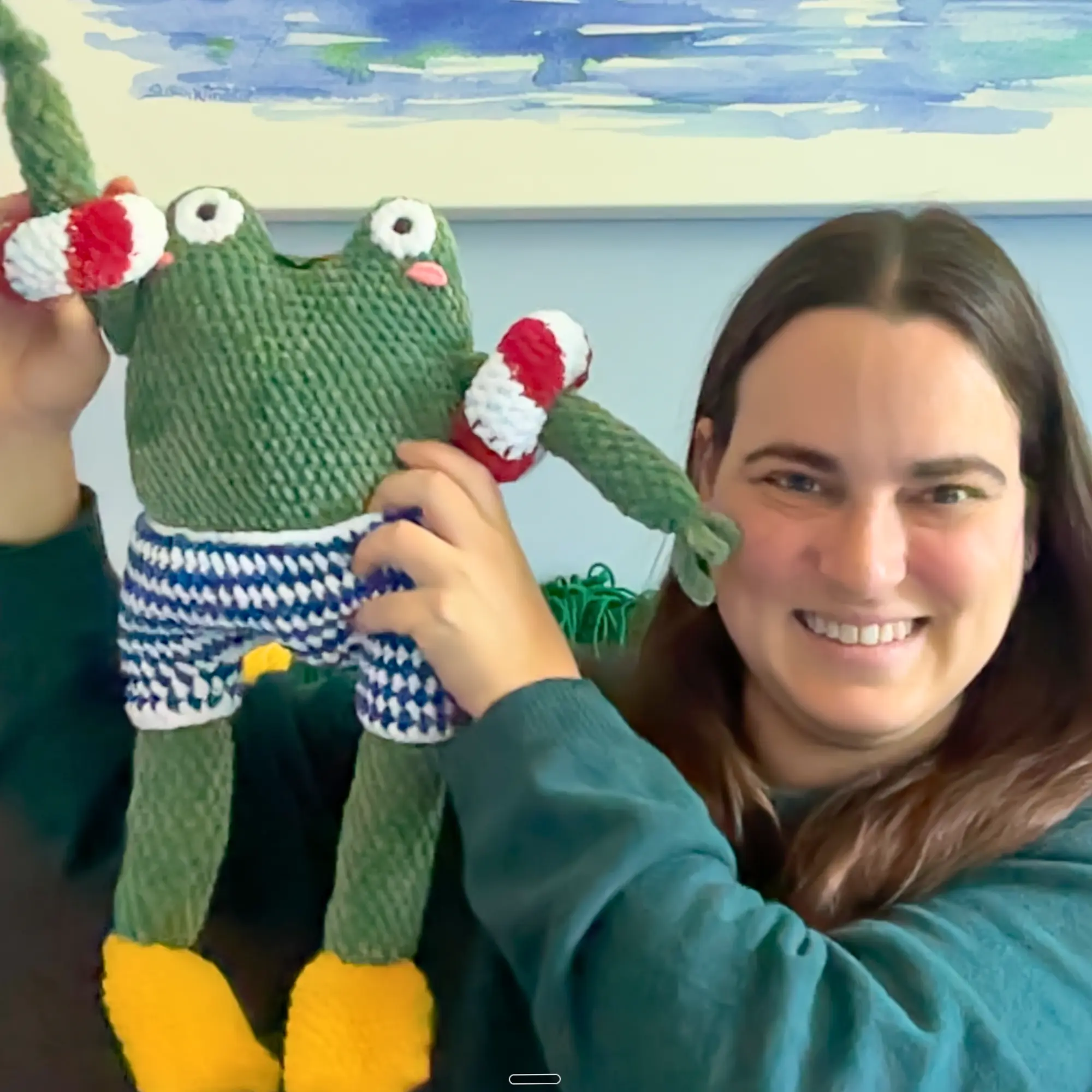 May holding a crocheted Victor Frog amigurumi plush